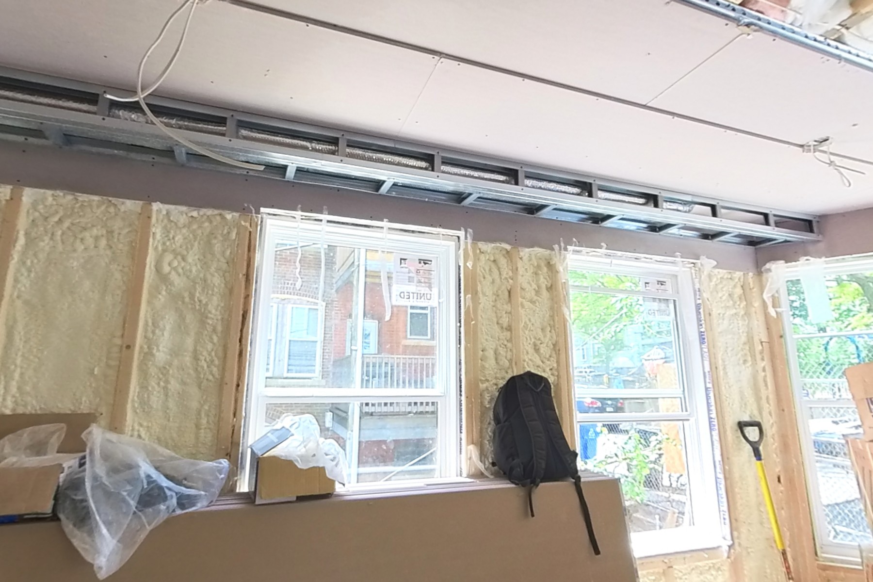 Ceiling drywall installation underway.