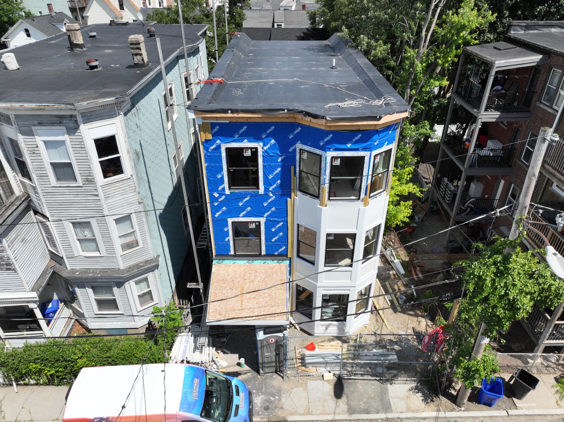 Windows installed; exterior siding and trim installation in progress on the front elevation.